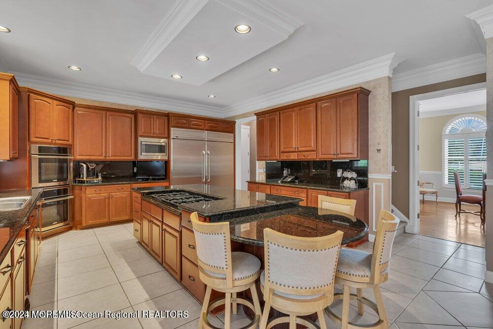 65 Cross Road Colts Neck, NJ 07722 - Photo 8 of 21 a kitchen with granite countertop a stove top oven a sink a dining table and chairs