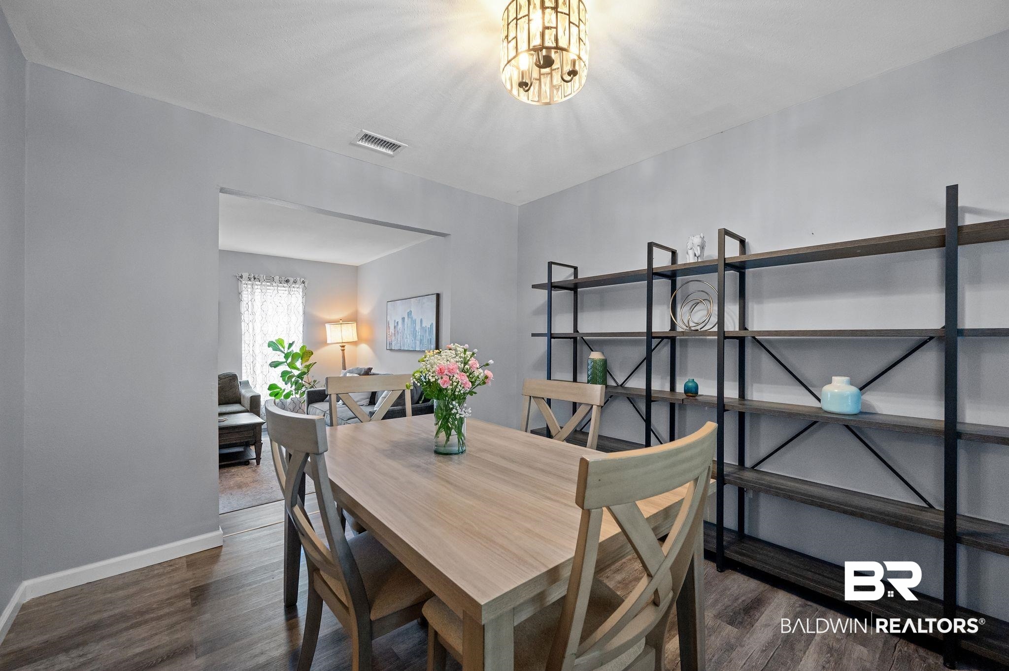 4724 Wicker Way Mobile, AL 36609 - Photo 9 of 36 Dining area featuring wood-finish flooring, light gray walls, and an ornate ceiling fixture