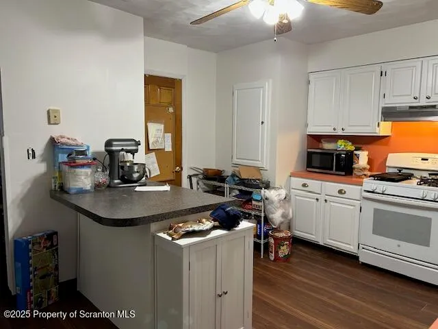 a kitchen with kitchen island granite countertop a sink cabinets and stainless steel appliances