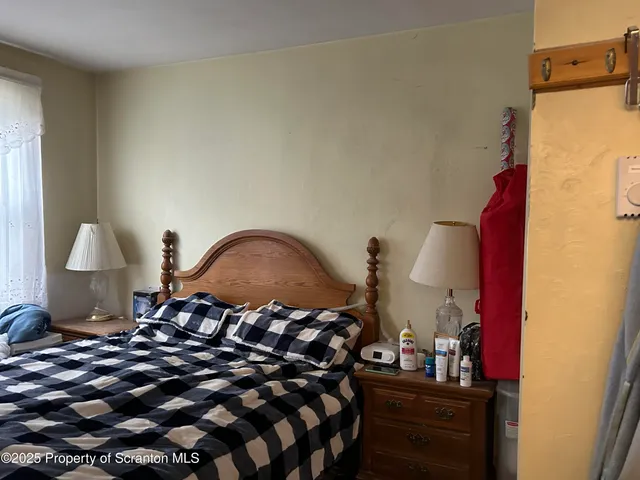 a bedroom with a bed and a lamp on dresser