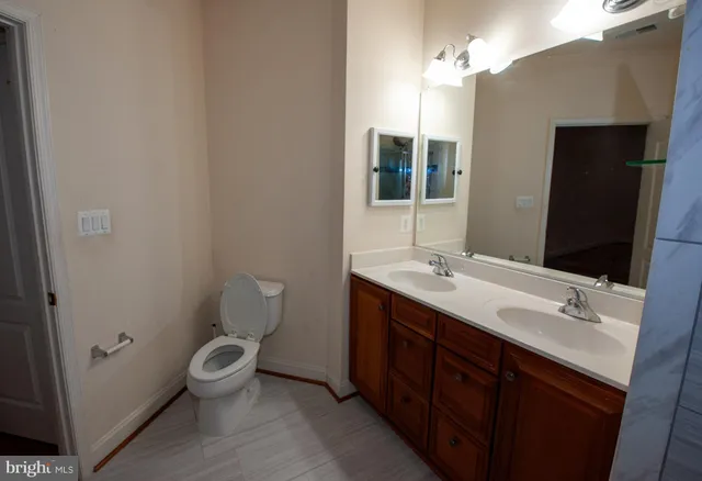 a bathroom with a double vanity sink toilet and mirror
