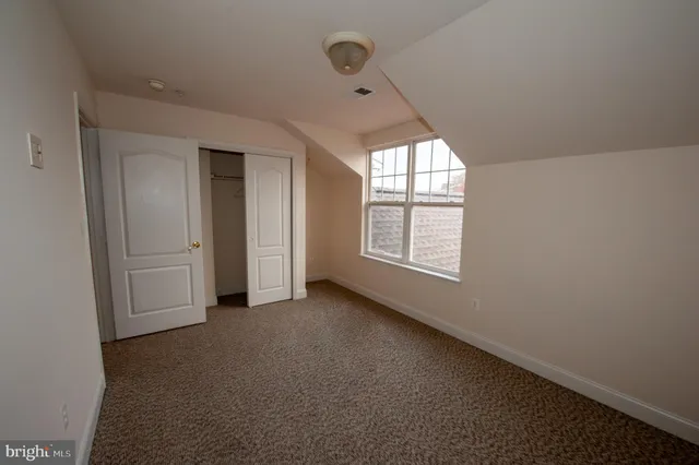 an empty room with windows and closet