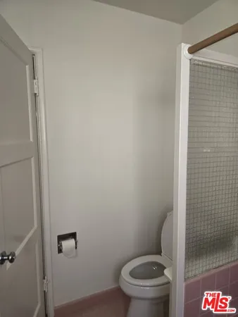 a white toilet sitting next to a shower