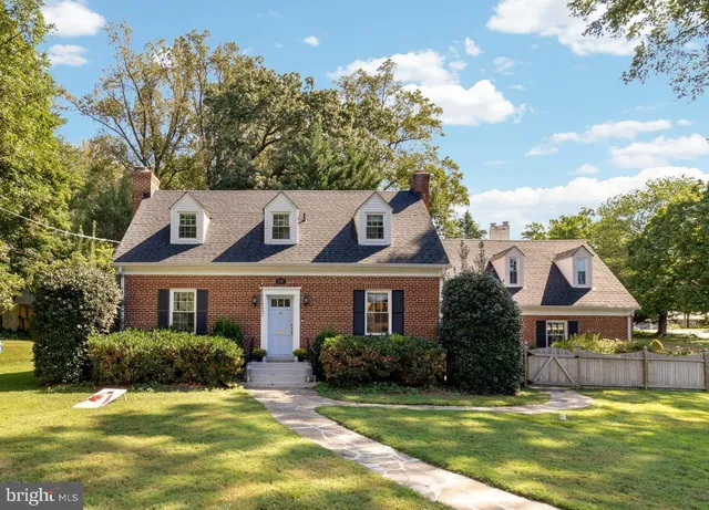 a front view of a house with a garden and swimming pool