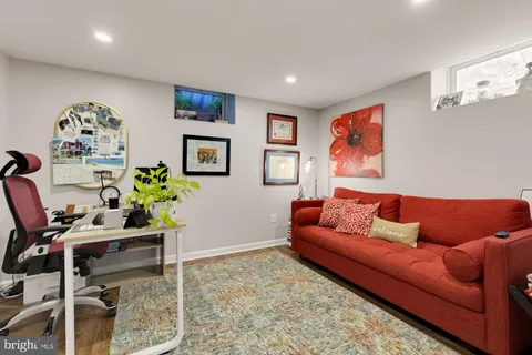 a living room with furniture and a dining table with wooden floor