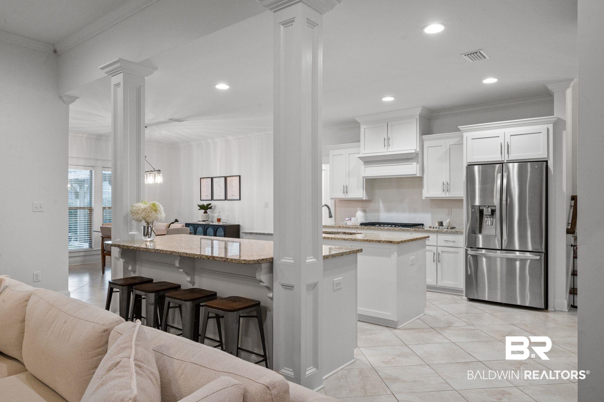 418 Fortune Drive Fairhope, AL 36532 - Photo 17 of 63 Kitchen with white cabinetry, light stone countertops, stainless steel appliances, and a kitchen island with sink