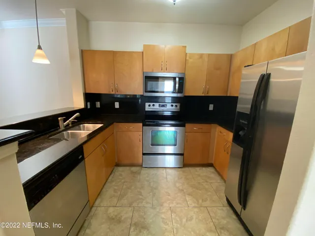 a kitchen with stainless steel appliances granite countertop a stove a refrigerator and a sink