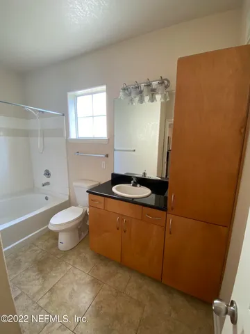 a bathroom with a granite countertop toilet and a sink