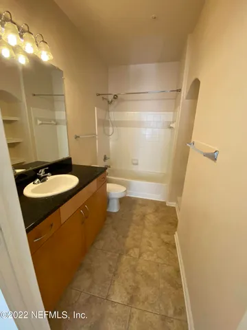 a bathroom with a granite countertop sink a mirror and a shower
