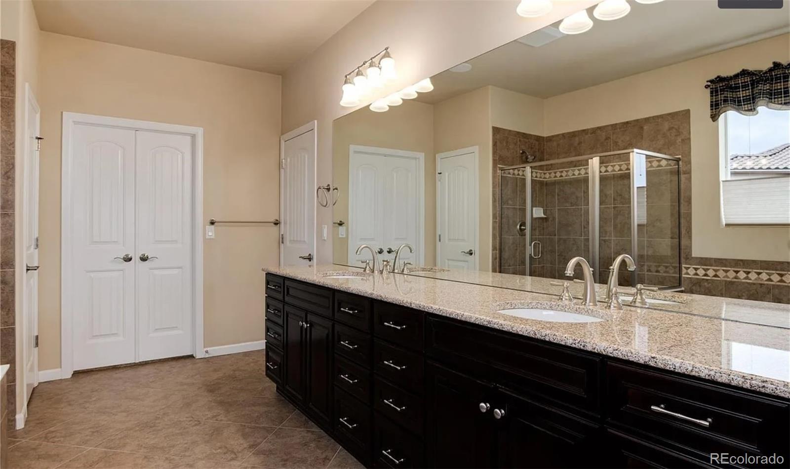 27235 East Lakeview Place Aurora, CO 80016 - Photo 14 of 22 a bathroom with double vanity sinks and a mirror