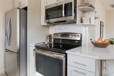 a kitchen with stainless steel appliances a sink a window and cabinets