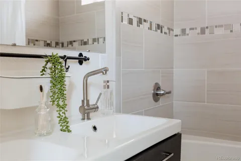 a bathroom with a granite countertop sink a toilet and shower
