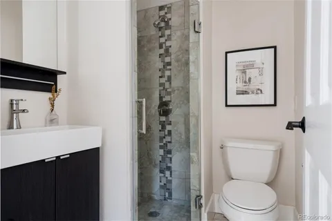 a bathroom with a shower a toilet and a sink