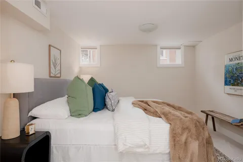 a large bed sitting in a bedroom next to a window