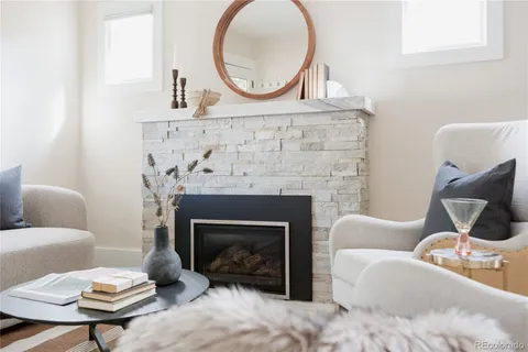 a living room with furniture a mirror and a fireplace