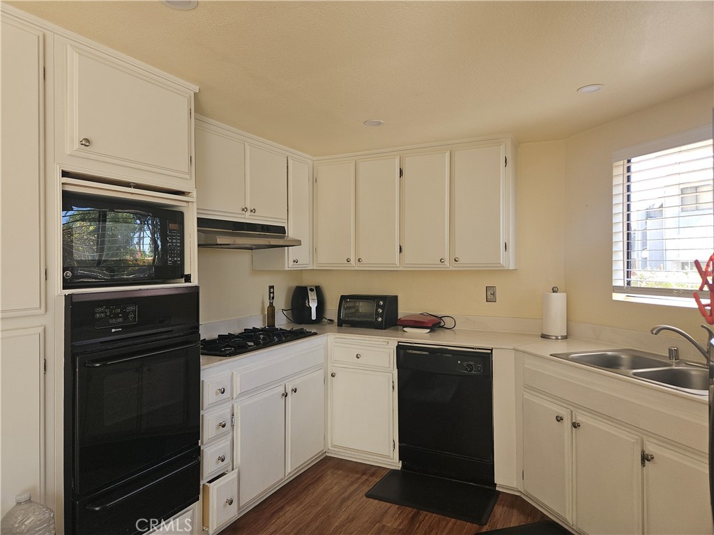3155 Ramon Road, Unit 601 Palm Springs, CA 92264 - Photo 15 of 35 a kitchen with granite countertop white cabinets and black appliances