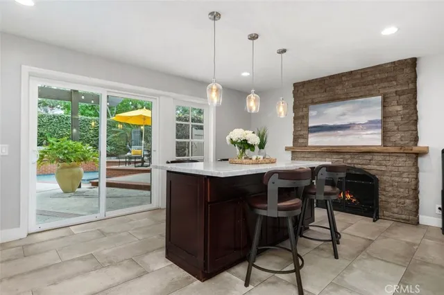 a kitchen with stainless steel appliances granite countertop a stove a sink a oven a dining table and chairs