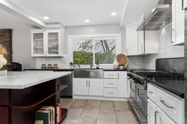 a kitchen with white cabinets and appliances