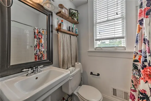 a bathroom with a sink a toilet and shower curtain