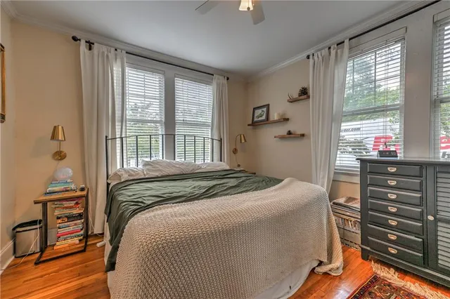 a bedroom with a bed and a dresser next to a window