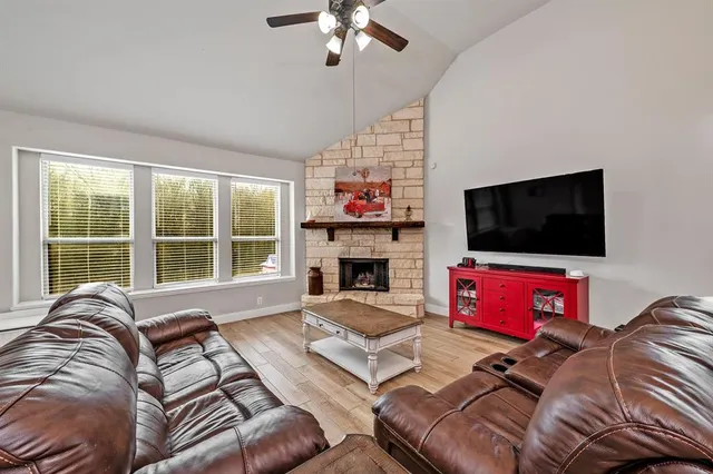a living room with furniture a flat screen tv and a fireplace
