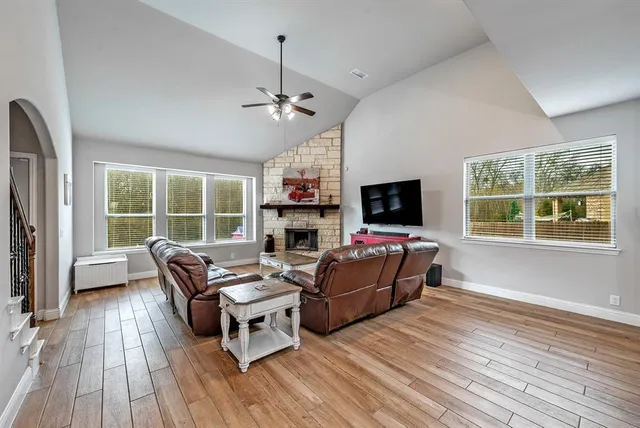 a living room with furniture a flat screen tv and a fireplace