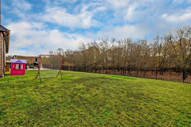 a view of a house with a big yard and a fountain