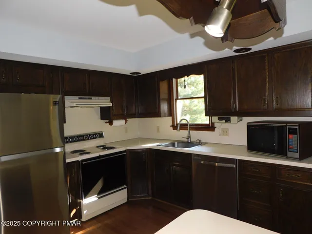 a kitchen with a sink stainless steel appliances and cabinets