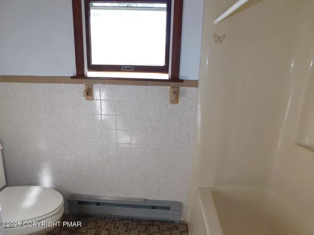 a bathroom with a toilet and a window
