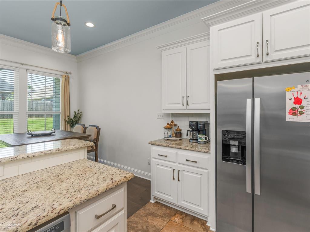690 Lessie Drive Stonewall, LA 71078 - Photo 13 of 29 Kitchen featuring a large stainless steel refrigerator, white cabinetry, and light speckled countertops