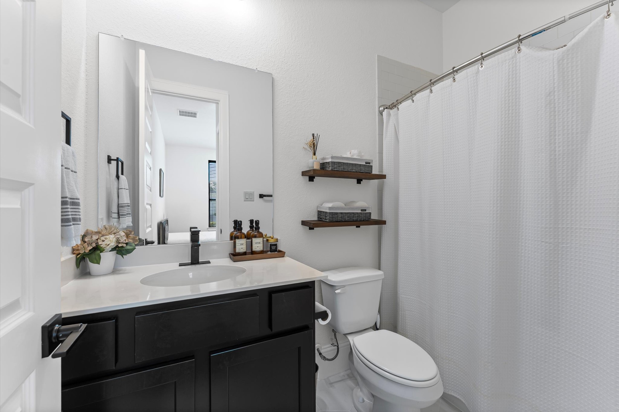 15470 Ringbill Way Magnolia, TX 77354 - Photo 41 of 50 a bathroom with a sink a toilet a mirror and shower curtain