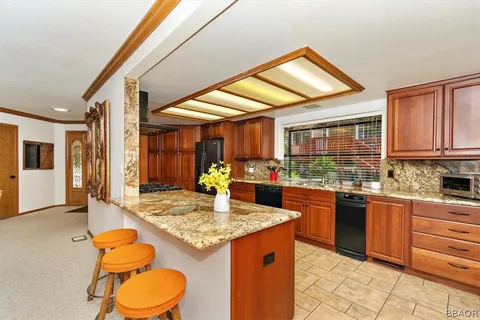 a kitchen with stainless steel appliances granite countertop sink stove and refrigerator