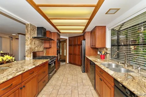 a kitchen with granite countertop a sink stove and cabinets