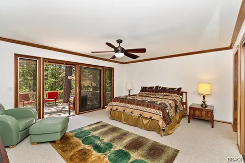 a spacious bedroom with a bed and glass walk in closet