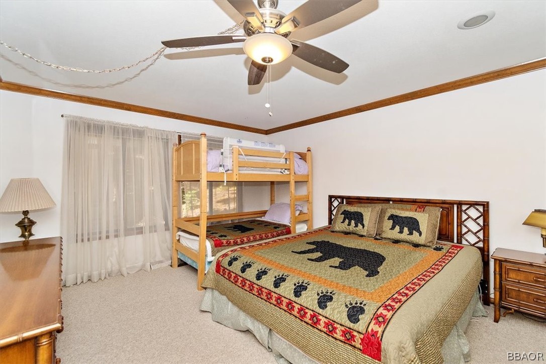 641 Golf Course Road Lake Arrowhead, CA 92352 - Photo 28 of 46 a bed sitting in a bedroom next to a window and a chandelier