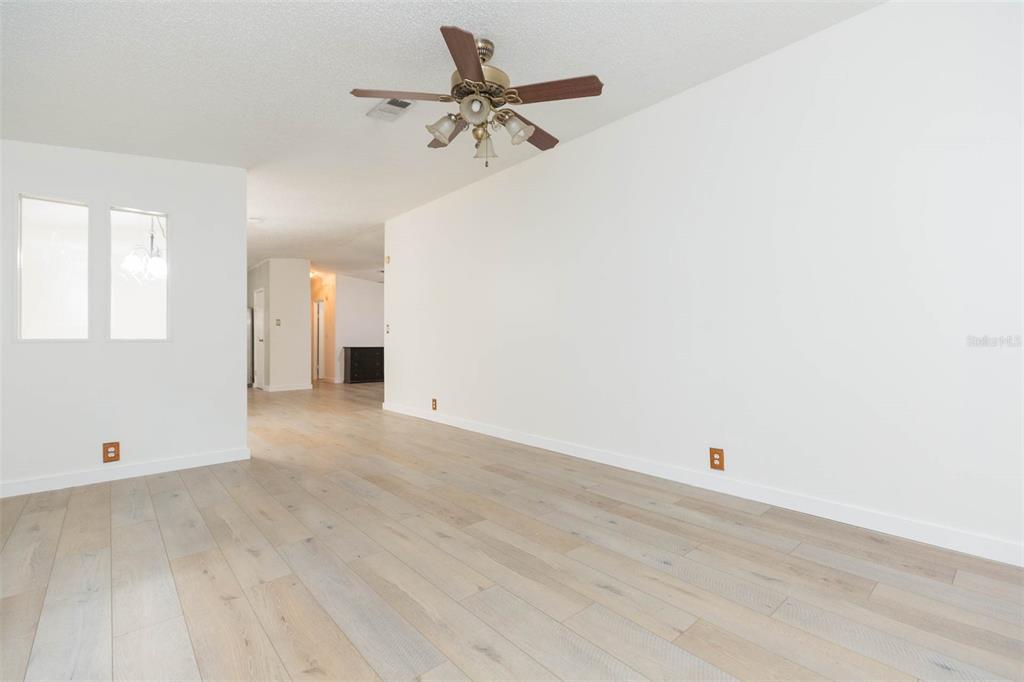12628 Fort King Road Dade City, FL 33525 - Photo 15 of 59 a view of a room with wooden floor and a ceiling fan