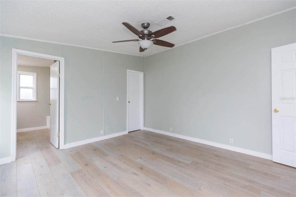 12628 Fort King Road Dade City, FL 33525 - Photo 28 of 59 an empty room with wooden floor and ceiling fan