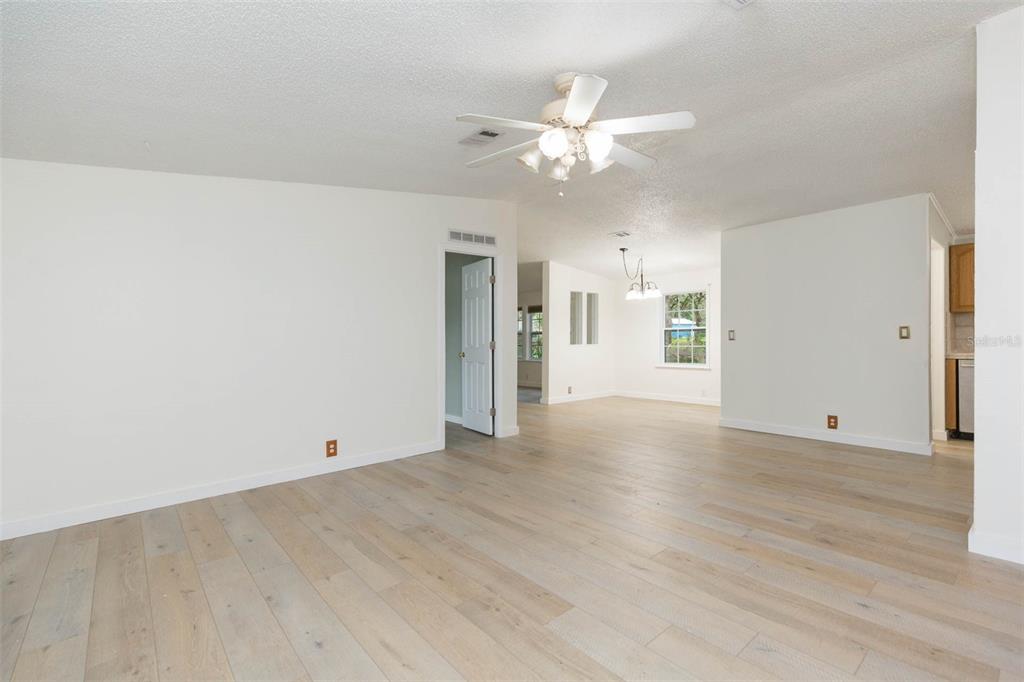 12628 Fort King Road Dade City, FL 33525 - Photo 3 of 59 a view of an empty room with wooden floor and a ceiling fan