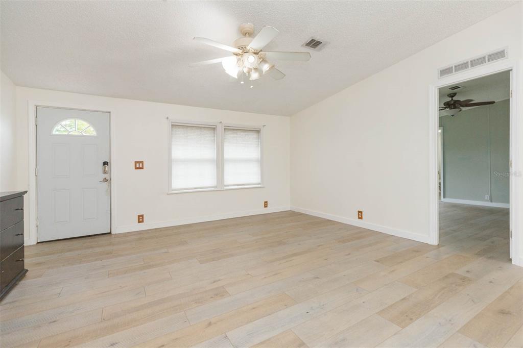 12628 Fort King Road Dade City, FL 33525 - Photo 8 of 59 an empty room with chandelier fan and windows