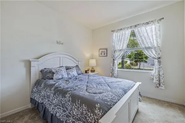 a bed sitting in a bedroom next to a window