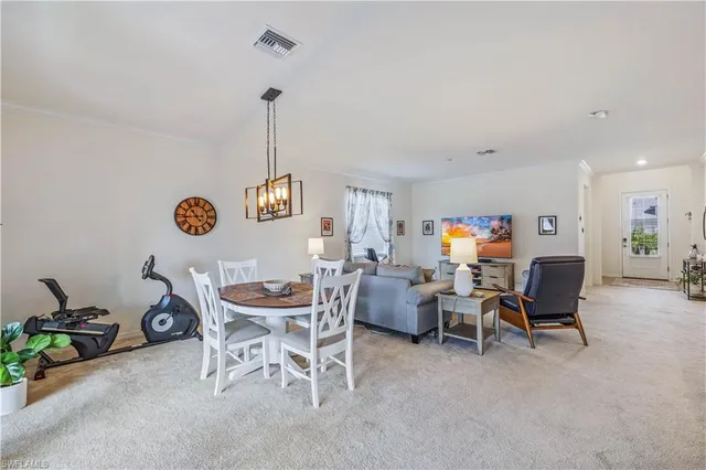 a dining room with furniture a chandelier and wooden floor