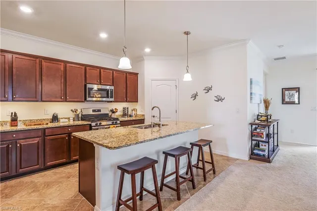 a kitchen with kitchen island granite countertop a table chairs sink and cabinets