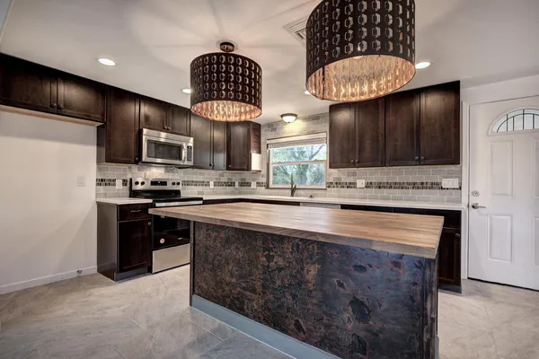 a kitchen with stainless steel appliances granite countertop a stove a refrigerator and a sink