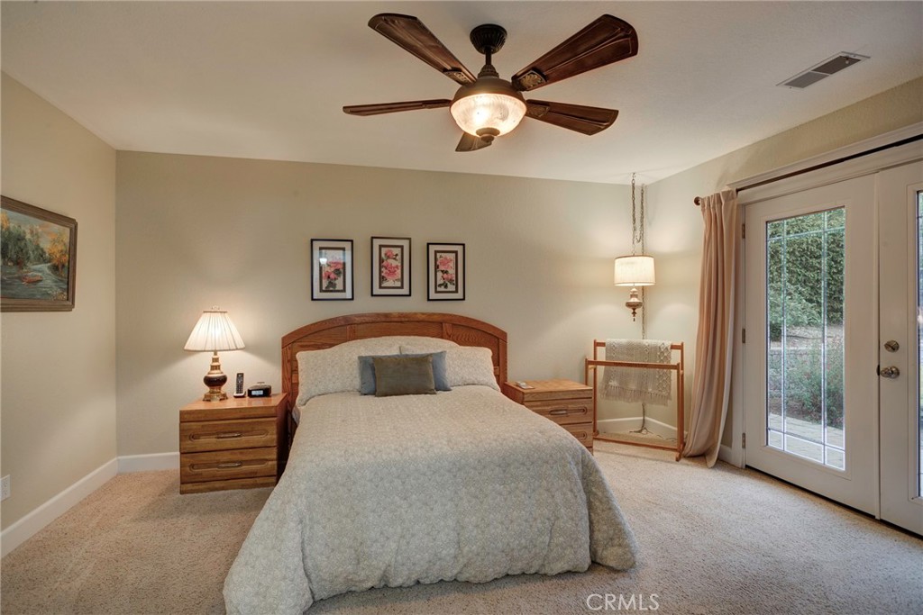 330 Stagecoach Road Arroyo Grande, CA 93420 - Photo 22 of 60 Bright primary bedroom featuring modern ceiling fan, and direct access to the outdoor patio through beveled glass French doors with retract-actable screens to enjoy the coastal climate.