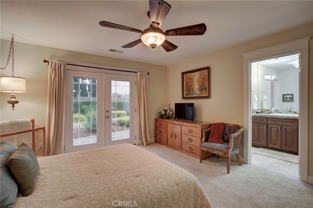 330 Stagecoach Road Arroyo Grande, CA 93420 - Photo 24 of 60 Bright bedroom featuring dual French doors, a cozy ambiance, and an en-suite bathroom for added convenience.