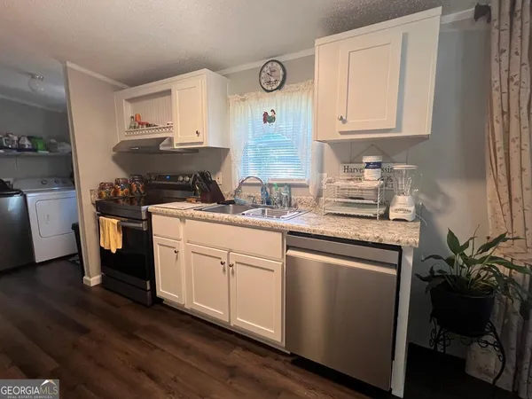 a kitchen with stainless steel appliances granite countertop a sink a stove and cabinets