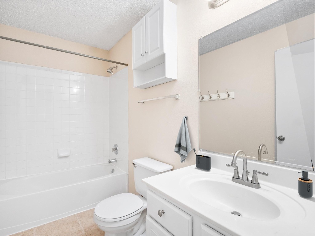 2727 High Point Drive Round Rock, TX 78664 - Photo 16 of 31 Bathroom with toilet, vanity, bathing tub / shower combination, and a textured ceiling