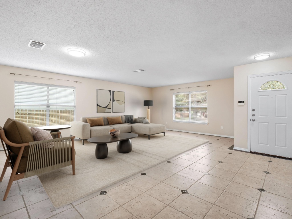2727 High Point Drive Round Rock, TX 78664 - Photo 2 of 31 Living room with a textured ceiling, baseboards, and light tile patterned flooring