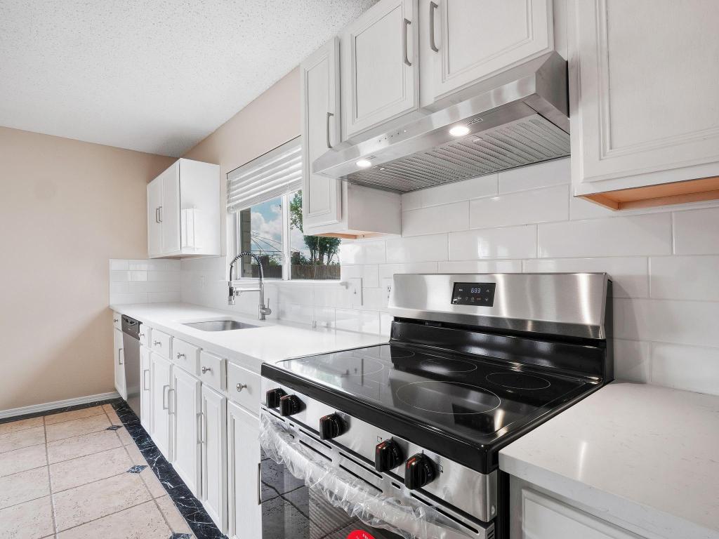 2727 High Point Drive Round Rock, TX 78664 - Photo 6 of 31 Kitchen with appliances with stainless steel finishes, extractor fan, a sink, white cabinets, and backsplash