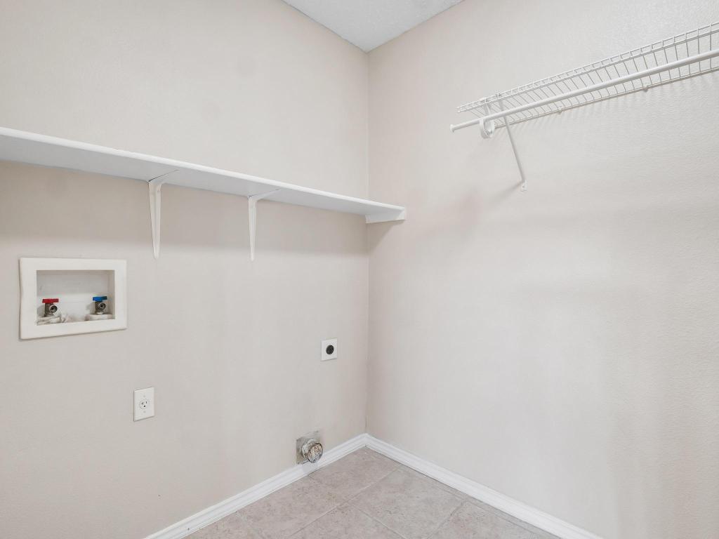 2727 High Point Drive Round Rock, TX 78664 - Photo 9 of 31 Laundry room with electric dryer hookup, washer hookup, baseboards, and light tile patterned floors